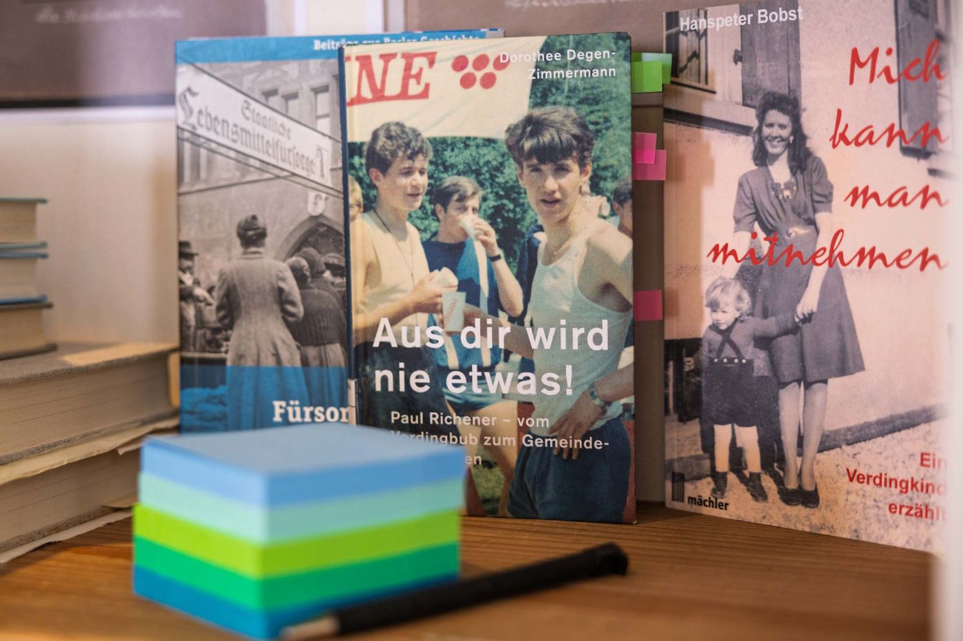 Ein Stift und Post-Its liegen vor verschiedenen Magazinen