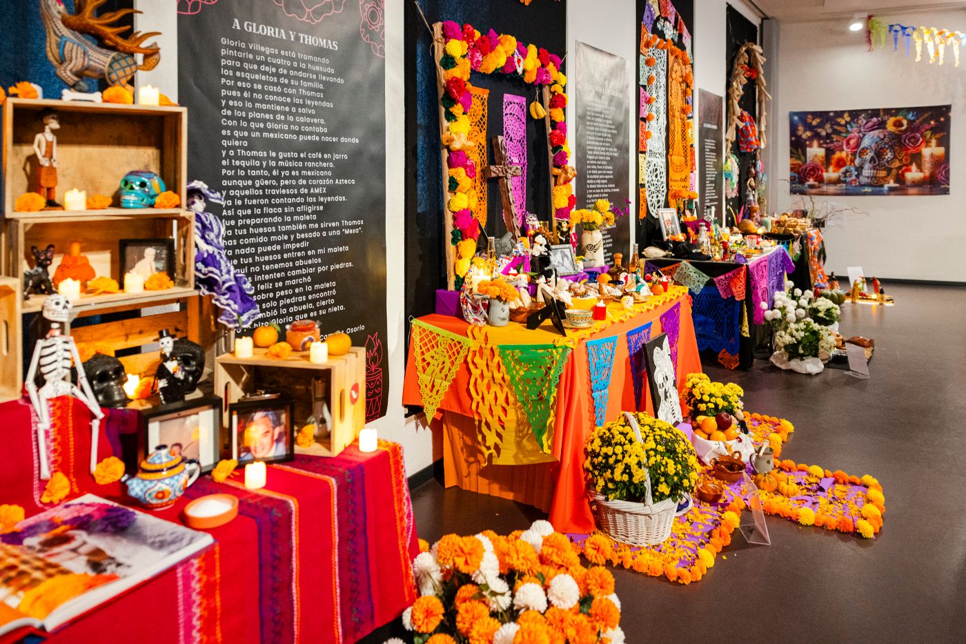 Ein farbenfroher Altar mit Fotos, Kerzen und Blumen, dekoriert für den Día de Muertos