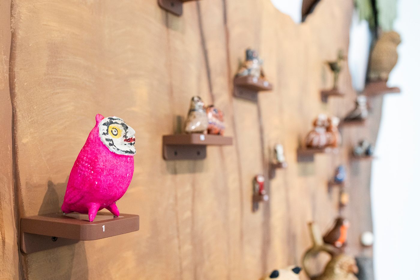 Toneule, die pink angemalt ist, zwei Beine und ein grosses rundes Gesicht hat.