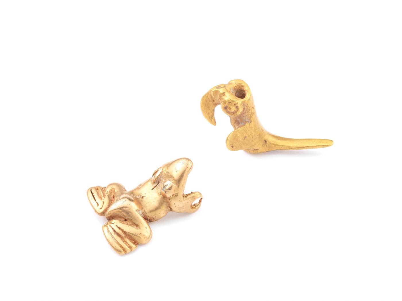 Zwei kleine, goldene Tierfiguren liegen auf einer weissen Oberfläche