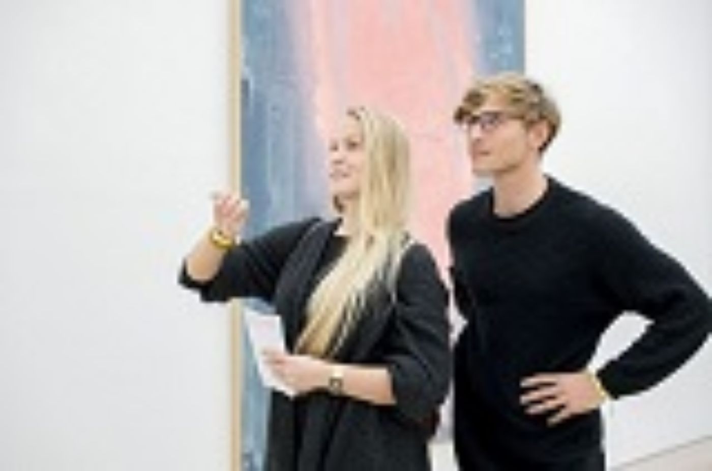 Zwei Menschen betrachten ein grossformatiges Kunstwerk, während sie lebhaft diskutieren