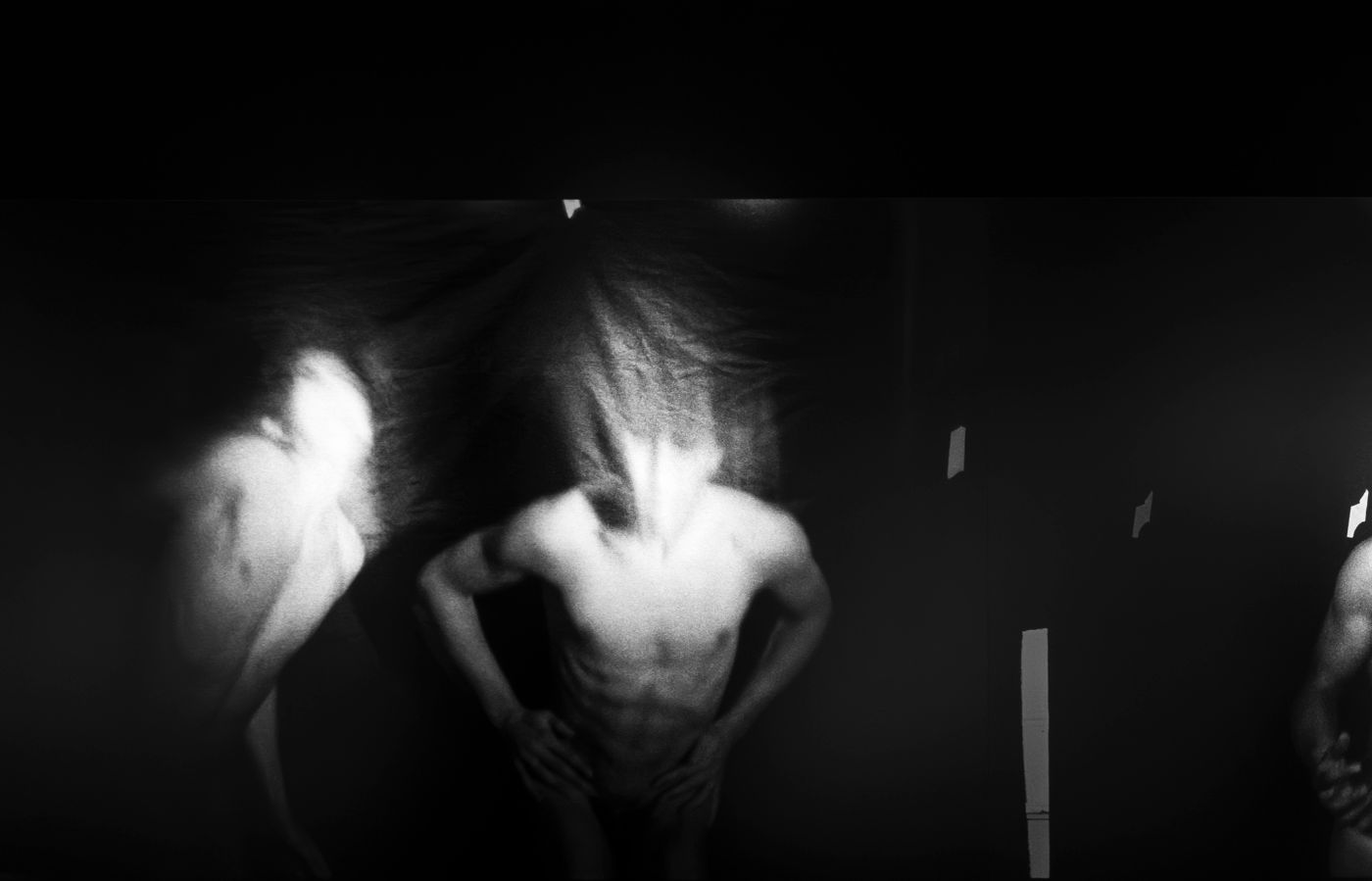 Ein verschwommener, tanzender Körper in Bewegung, der in einem dunklen Raum dynamisch wirkt