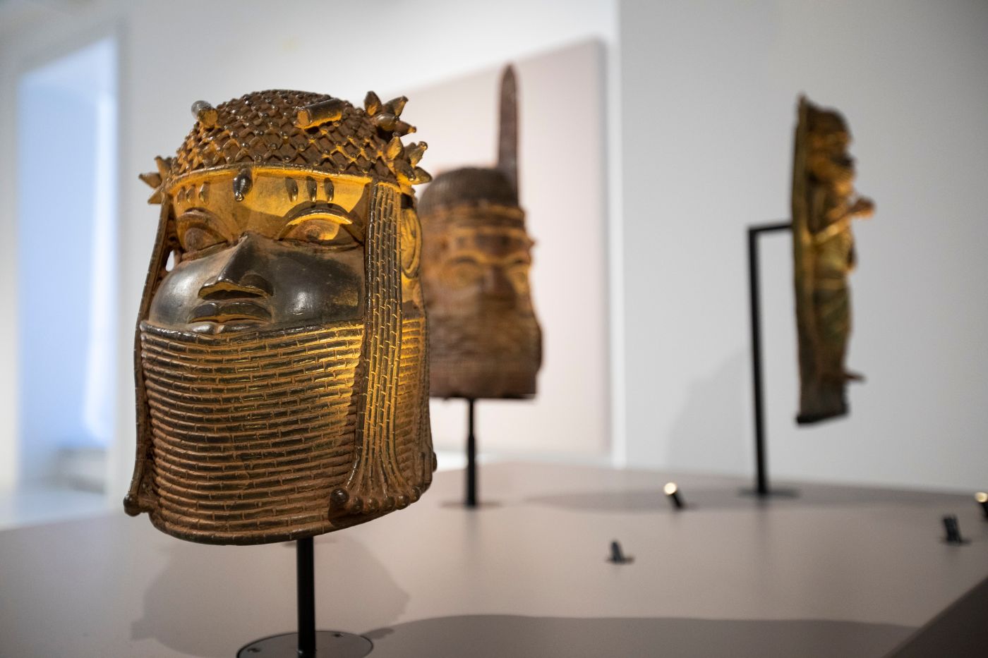 Drei Bronzeskulpturen in einem Ausstellungsraum, die kunstvoll im Licht arrangiert sind