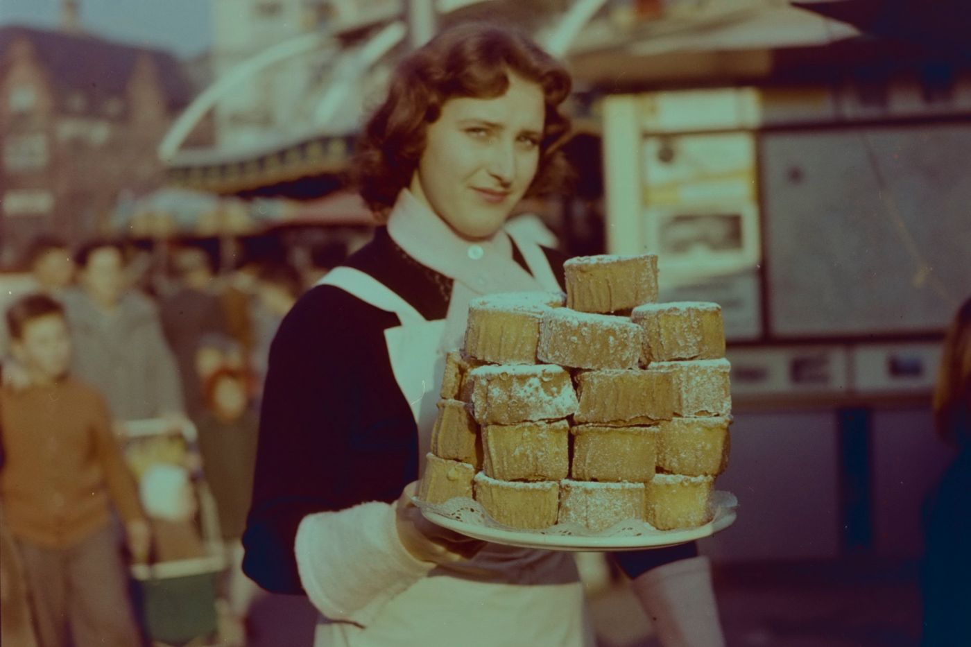 Frau mit einem Teller «Rosekiechli» an der Basler Herbstmesse, 1950er-Jahre
