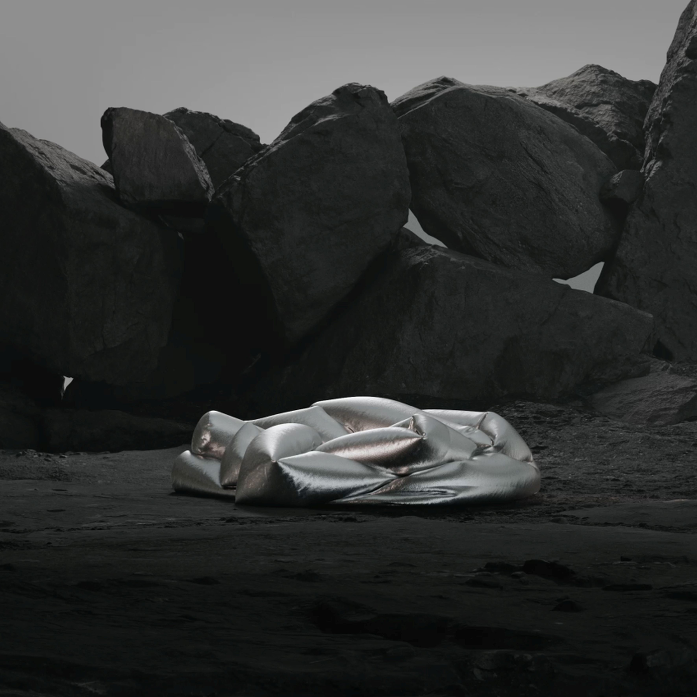 On a black rocky ground, a futuristic, silver-gloss sofa sits before massive boulders.