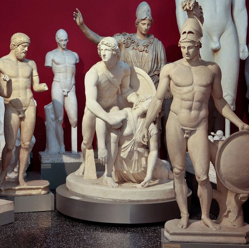 Gipsplastiken gruppiert vor einer roten Wand