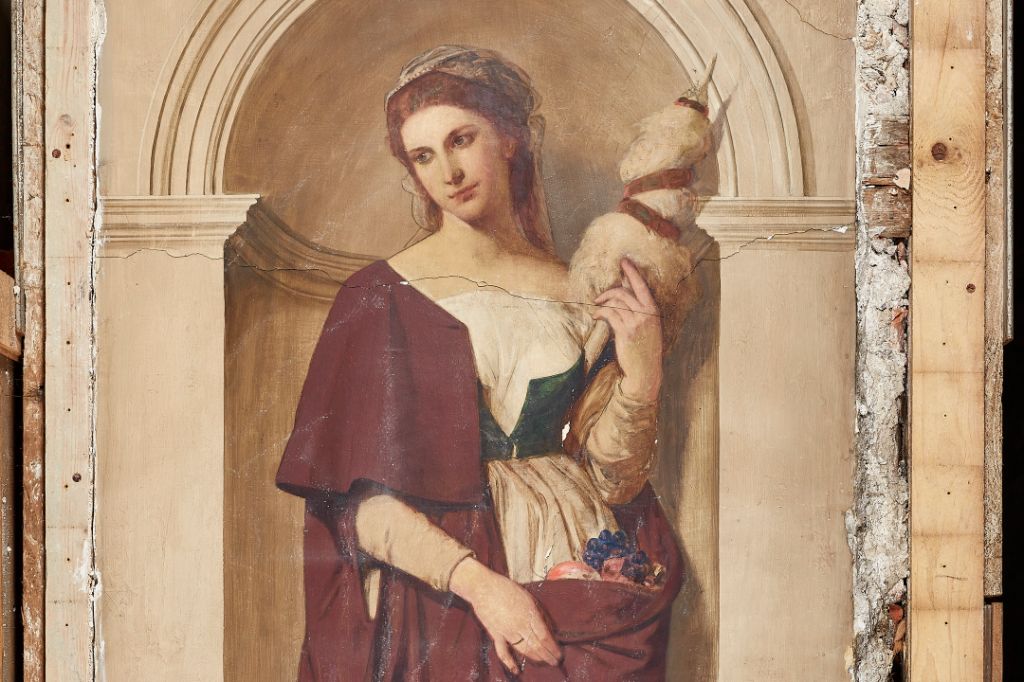 A woman in historical clothing stands with a distaff and fruit basket before an arched niche